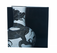 Photo depicts the back of the book, which is void of text and features a close-up image of a white, Chinese vase etched with a black dragon. Background is solid black. 